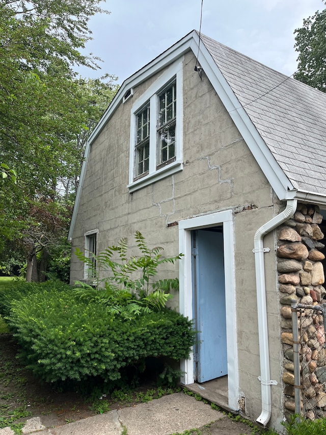 view of side of home featuring roof with shingles