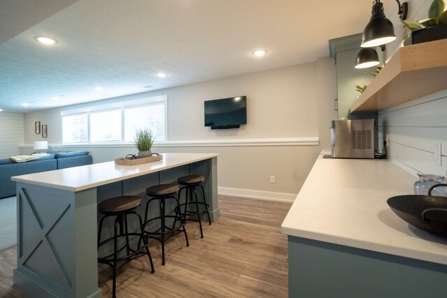 3280 Amtrak Dr SW, Byron Center, MI 49315 - kitchen with a center island, light countertops, a kitchen breakfast bar, light wood finished floors, and recessed lighting