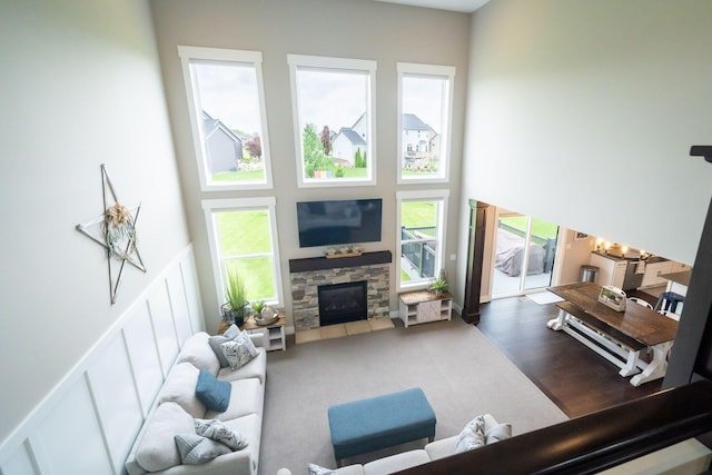 3280 Amtrak Dr SW, Byron Center, MI 49315 - living area featuring a decorative wall, a fireplace, a high ceiling, wainscoting, and a chandelier