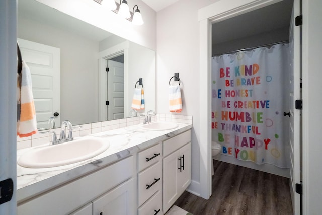 3280 Amtrak Dr SW, Byron Center, MI 49315 - bathroom with wood finished floors, toilet, double vanity, and curtained shower