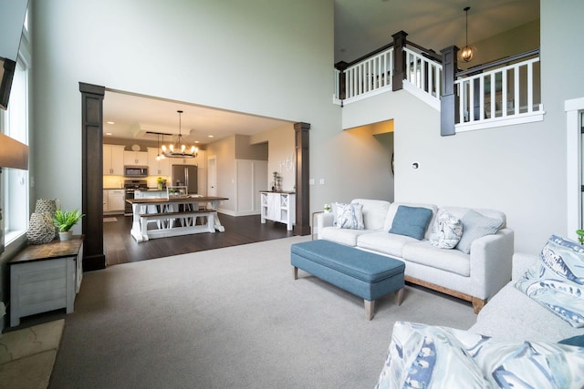3280 Amtrak Dr SW, Byron Center, MI 49315 - living area featuring a high ceiling, dark wood-type flooring, a chandelier, and decorative columns