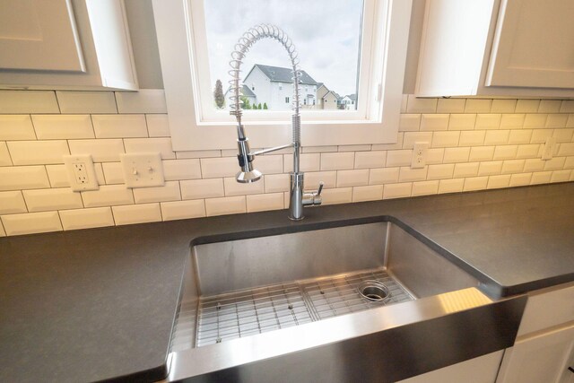 3280 Amtrak Dr SW, Byron Center, MI 49315 - kitchen view of dark countertops, a sink, and decorative backsplash