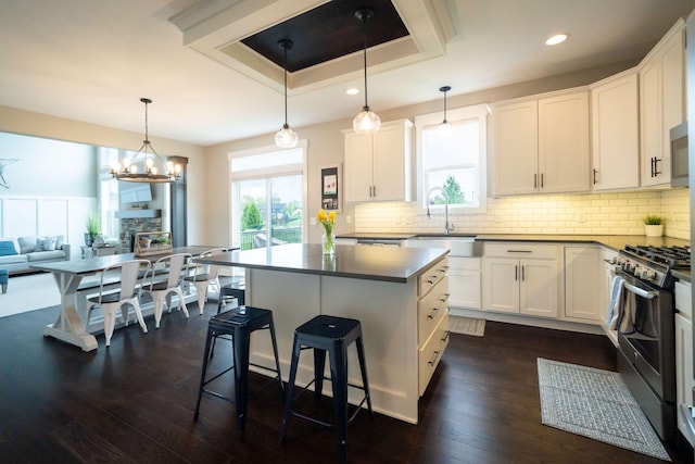 3280 Amtrak Dr SW, Byron Center, MI 49315 - kitchen featuring stainless steel gas stove, a sink, dark wood finished floors, a center island, and plenty of natural light