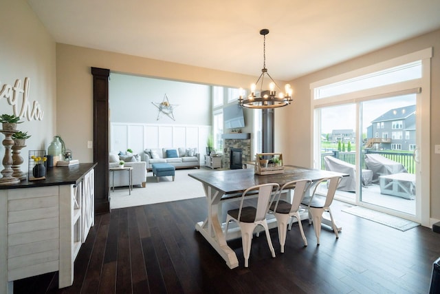 3280 Amtrak Dr SW, Byron Center, MI 49315 - dining space with a fireplace, healthy amount of natural light, a chandelier, and dark wood-style floors