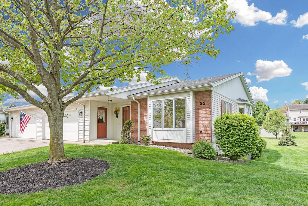 2809 Bridgeside Dr SE, Caledonia, MI 49316 - ranch-style home with concrete driveway, brick siding, a front yard, and a garage