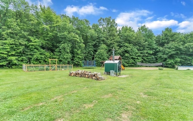 5856 Peck Rd, Brown City, MI 48416 - view of grassy yard with a trampoline, a playground, a storage shed, and an outbuilding