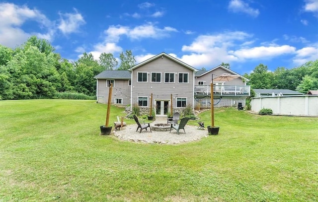 5856 Peck Rd, Brown City, MI 48416 - back of property with a fire pit, french doors, a deck, and a lawn