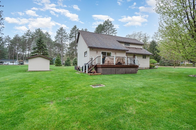 217 Maple Rd, Roscommon, MI 48653 - rear view of house featuring roof with shingles, a wooden deck, a yard, and an outdoor structure