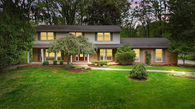 1558 Sylvan Glen Rd, Okemos, MI 48864 - view of front of home featuring a front lawn, brick siding, and covered porch