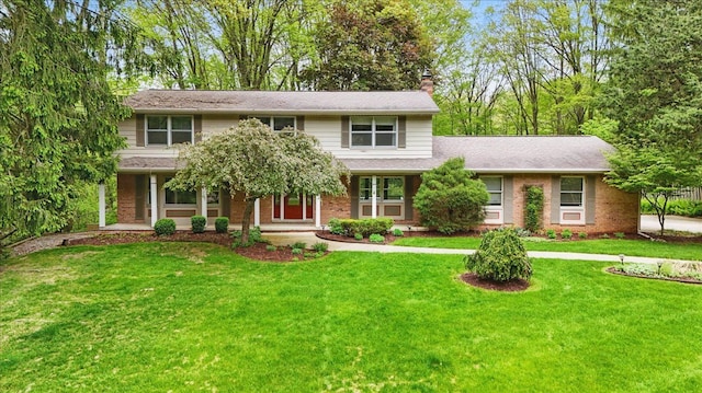 1558 Sylvan Glen Rd, Okemos, MI 48864 - view of front of home featuring a chimney, a front lawn, brick siding, and covered porch