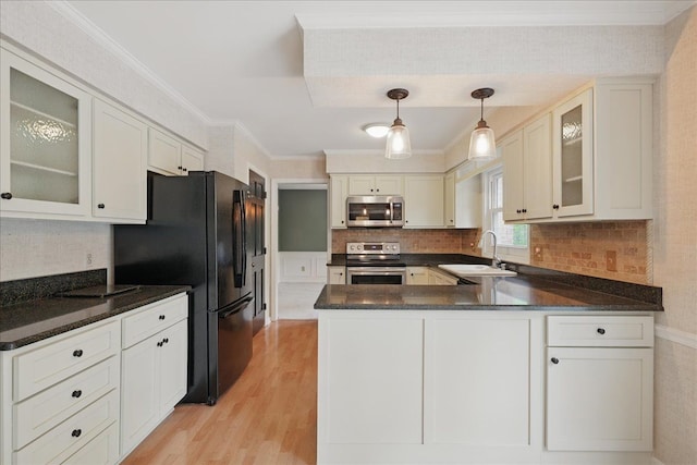 1558 Sylvan Glen Rd, Okemos, MI 48864 - kitchen featuring appliances with stainless steel finishes, a sink, a peninsula, light wood-type flooring, and ornamental molding