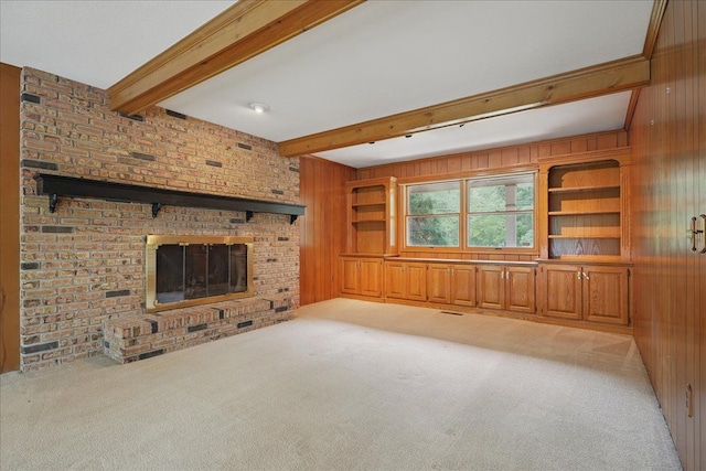 1558 Sylvan Glen Rd, Okemos, MI 48864 - unfurnished living room featuring light carpet, wood walls, beam ceiling, and a fireplace