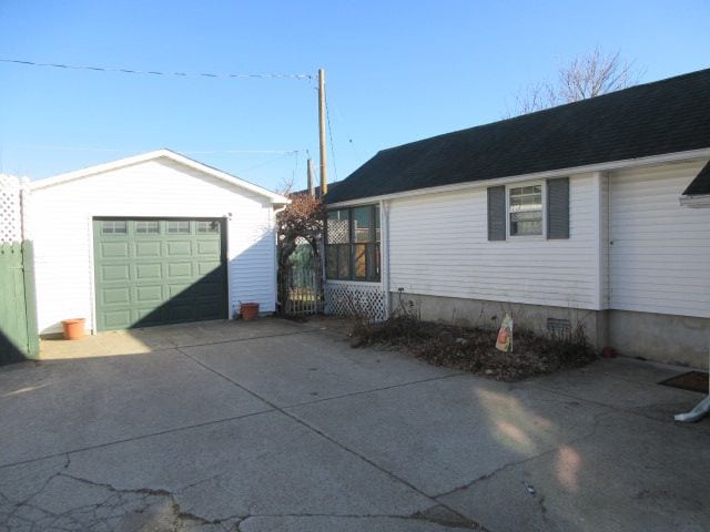 110 N 1st St, Holly, MI 48442 - view of home's exterior with a garage, an outdoor structure, and driveway