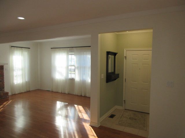110 N 1st St, Holly, MI 48442 - unfurnished living room with wood finished floors, baseboards, recessed lighting, and crown molding