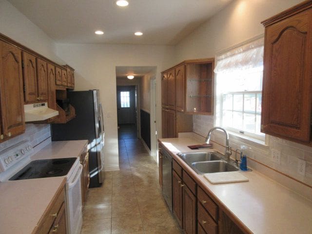 110 N 1st St, Holly, MI 48442 - kitchen featuring white electric range, a sink, exhaust hood, backsplash, and recessed lighting