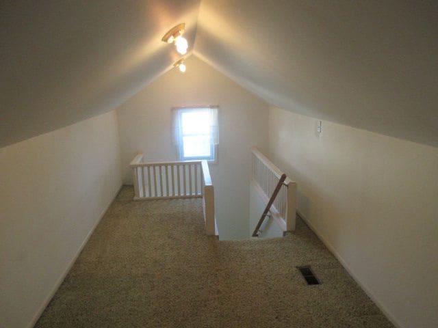110 N 1st St, Holly, MI 48442 - additional living space with carpet flooring and vaulted ceiling