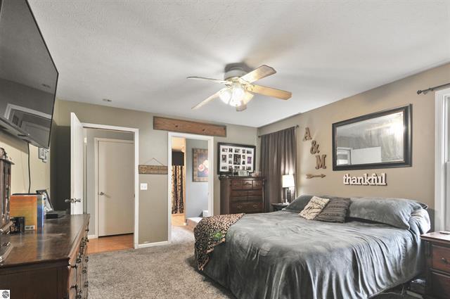2426 E 48 1/2 Rd, Cadillac, MI 49601 - bedroom with light carpet and a ceiling fan