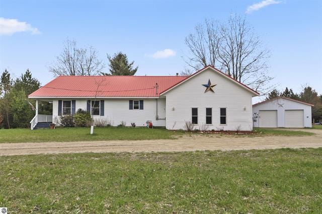 2426 E 48 1/2 Rd, Cadillac, MI 49601 - view of front of house with a detached garage, an outbuilding, a front lawn, and metal roof