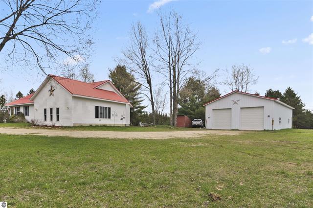 2426 E 48 1/2 Rd, Cadillac, MI 49601 - view of grassy yard with a garage and an outdoor structure