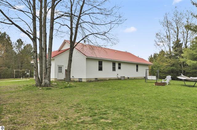 2426 E 48 1/2 Rd, Cadillac, MI 49601 - rear view of house with a yard and metal roof