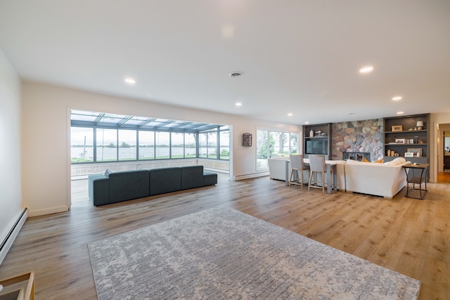 27607 Elba Dr, Grosse Ile, MI 48138 - living room featuring light wood-style floors, a baseboard heating unit, a fireplace, recessed lighting, and baseboards