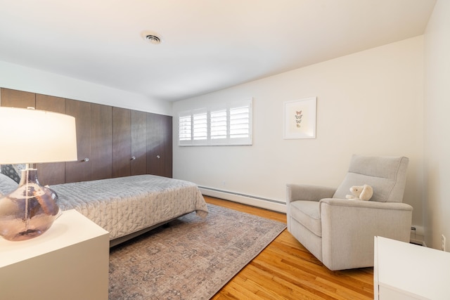 27607 Elba Dr, Grosse Ile, MI 48138 - bedroom with baseboard heating and light wood finished floors