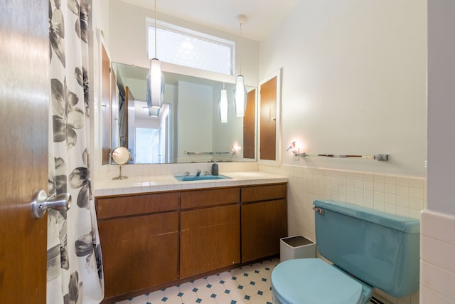 27607 Elba Dr, Grosse Ile, MI 48138 - full bathroom featuring toilet, vanity, tile walls, and wainscoting