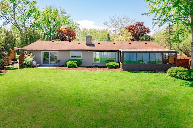 27607 Elba Dr, Grosse Ile, MI 48138 - rear view of house featuring a chimney, a yard, a sunroom, and a patio area
