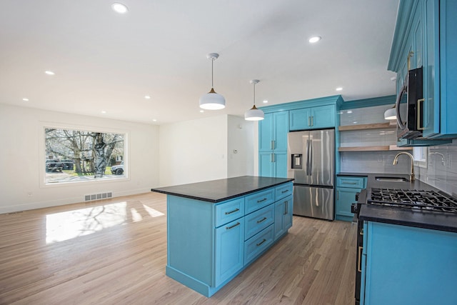 38501 Winkler St, Harrison Township, MI 48045 - kitchen with stainless steel appliances, a sink, dark countertops, blue cabinets, and light wood finished floors