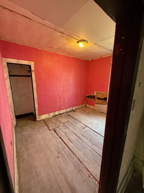 15779 Alden St, Detroit, MI 48238 - spare room featuring wood-type flooring, a textured wall, and baseboards