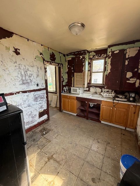 15779 Alden St, Detroit, MI 48238 - kitchen with light countertops, white microwave, brown cabinets, and open shelves
