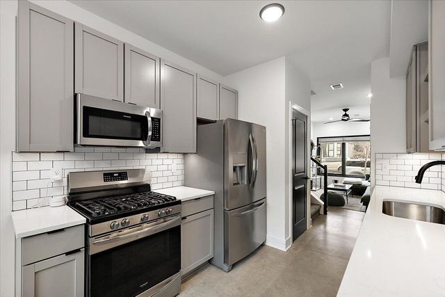 3313 Cochrane St, Detroit, MI 48208 - kitchen with appliances with stainless steel finishes, a sink, gray cabinetry, light countertops, and a ceiling fan