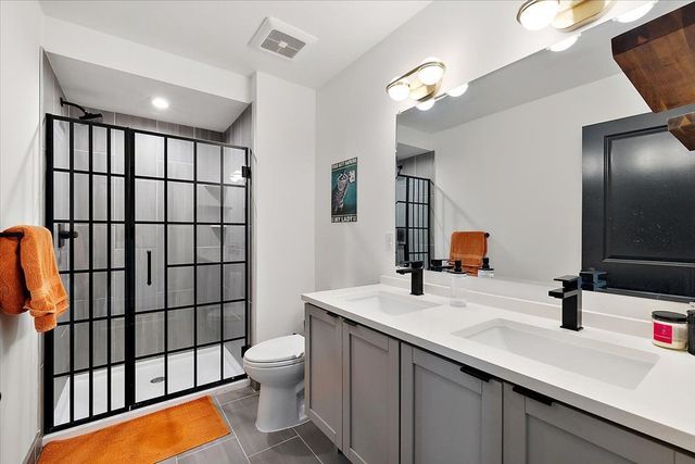3313 Cochrane St, Detroit, MI 48208 - full bathroom with tile patterned flooring, tiled shower, toilet, and double vanity