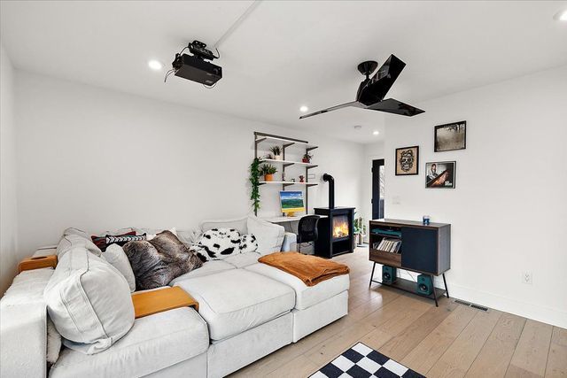 3313 Cochrane St, Detroit, MI 48208 - living room featuring a wood stove, recessed lighting, light wood-style flooring, and baseboards