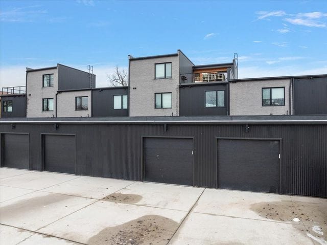 3313 Cochrane St, Detroit, MI 48208 - rear view of property with an attached garage, driveway, and stucco siding