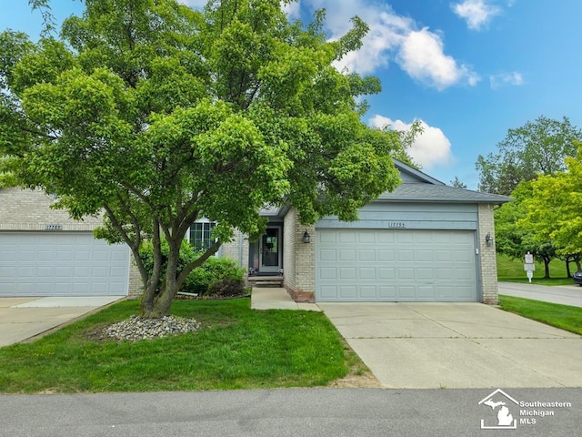 17795 Bobwhite Ct, Brownstown, MI 48192 - view of property hidden behind natural elements featuring brick siding, a front lawn, concrete driveway, and an attached garage