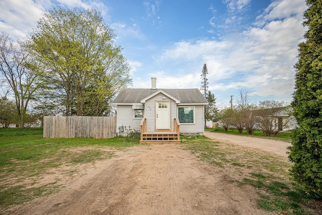 505 S Cherry St, Kalkaska, MI 49646 - bungalow-style home featuring fence, driveway, and a chimney