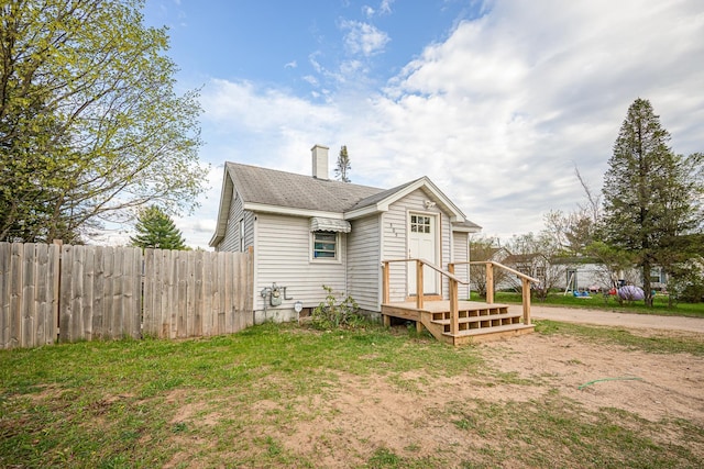 505 S Cherry St, Kalkaska, MI 49646 - view of front of house with fence and a chimney