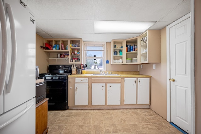 505 S Cherry St, Kalkaska, MI 49646 - kitchen with white appliances, open shelves, a sink, light countertops, and a paneled ceiling