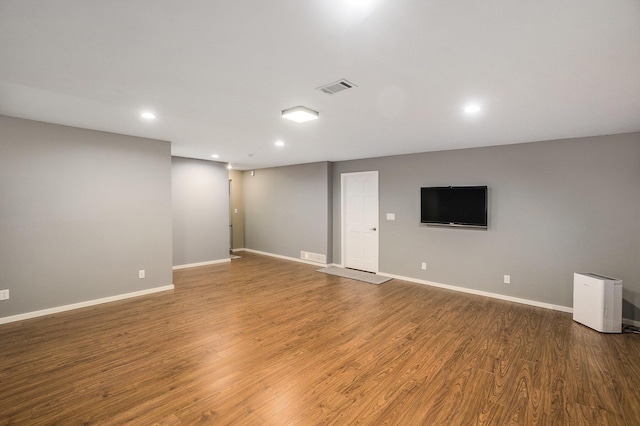 empty room with recessed lighting, baseboards, and wood finished floors