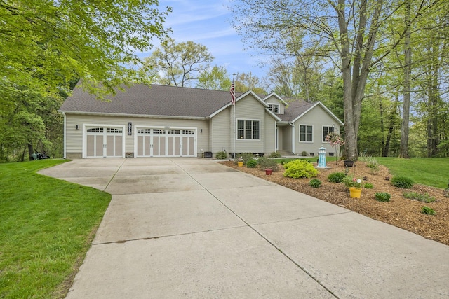 view of front of home with concrete driveway, an attached garage, and a front lawn