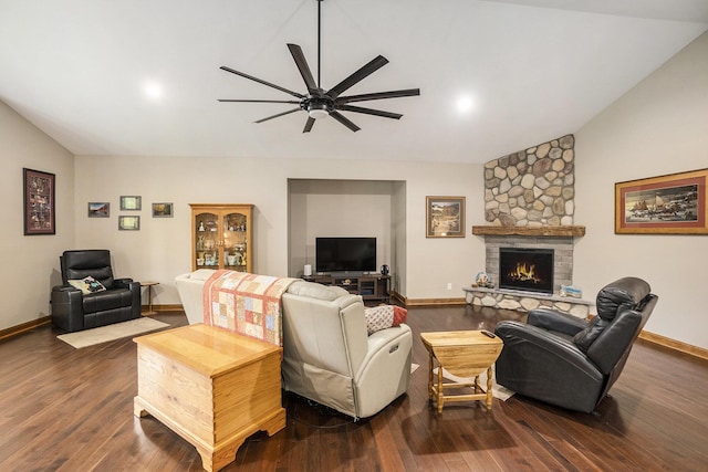 living area with lofted ceiling, ceiling fan, dark wood-type flooring, baseboards, and a stone fireplace