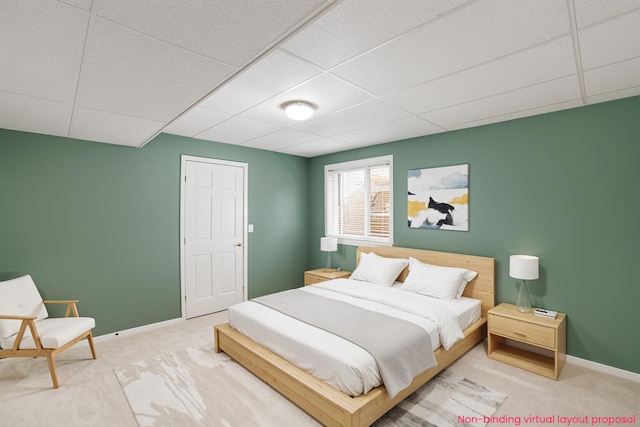 carpeted bedroom with a paneled ceiling and baseboards