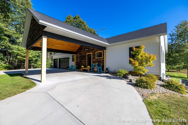 12640 Bucs Dr, Grand Haven, MI 49417 - view of home's exterior featuring concrete driveway, a garage, roof with shingles, and a yard