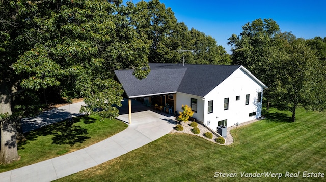 12640 Bucs Dr, Grand Haven, MI 49417 - view of front of home featuring driveway, a front lawn, roof with shingles, and a carport