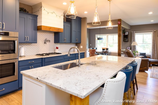 12640 Bucs Dr, Grand Haven, MI 49417 - kitchen featuring a sink, stainless steel appliances, light wood-style flooring, blue cabinets, and recessed lighting