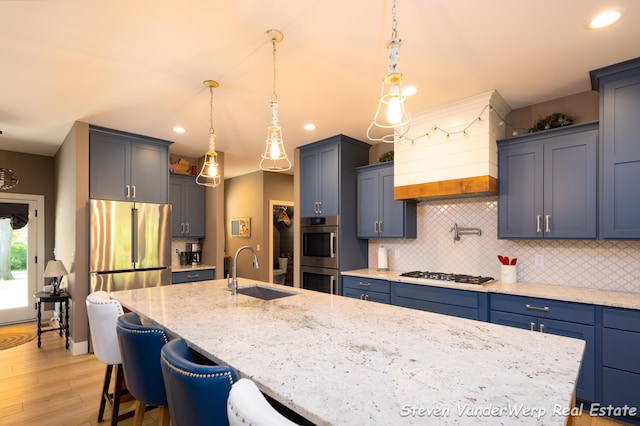 12640 Bucs Dr, Grand Haven, MI 49417 - kitchen with a sink, stainless steel appliances, custom exhaust hood, recessed lighting, and a center island with sink