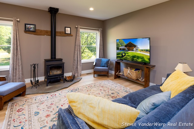 12640 Bucs Dr, Grand Haven, MI 49417 - living room with a wood stove, plenty of natural light, wood finished floors, recessed lighting, and baseboards