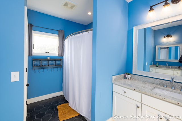 12640 Bucs Dr, Grand Haven, MI 49417 - full bathroom with vanity, tile patterned floors, baseboards, and a shower with curtain