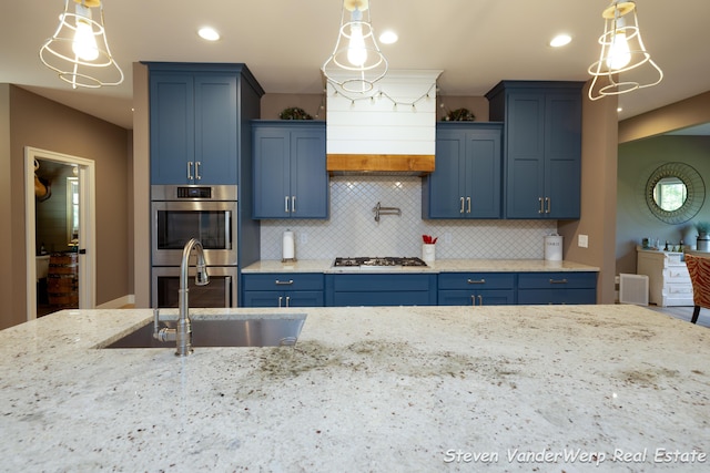 12640 Bucs Dr, Grand Haven, MI 49417 - kitchen with blue cabinets, a sink, double oven, gas cooktop, and backsplash